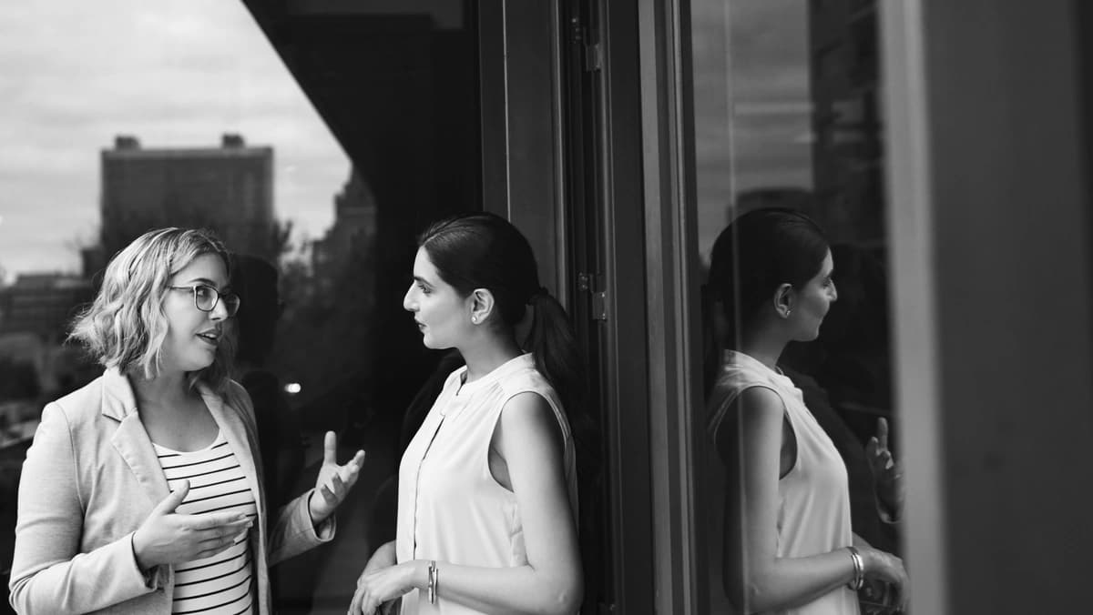 two women talking outside a building