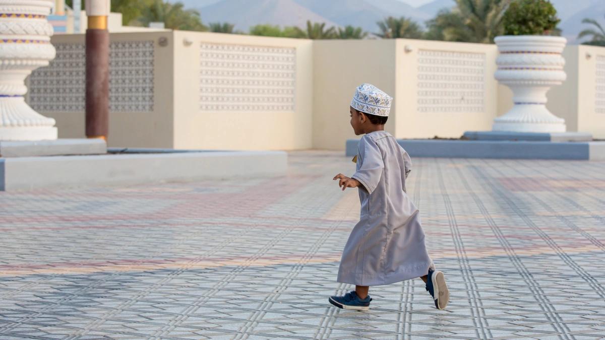 A boy runs in a paved courtyard