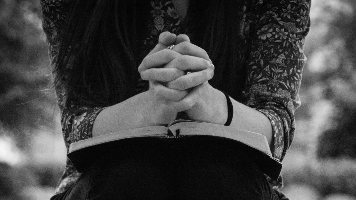 woman praying over bible